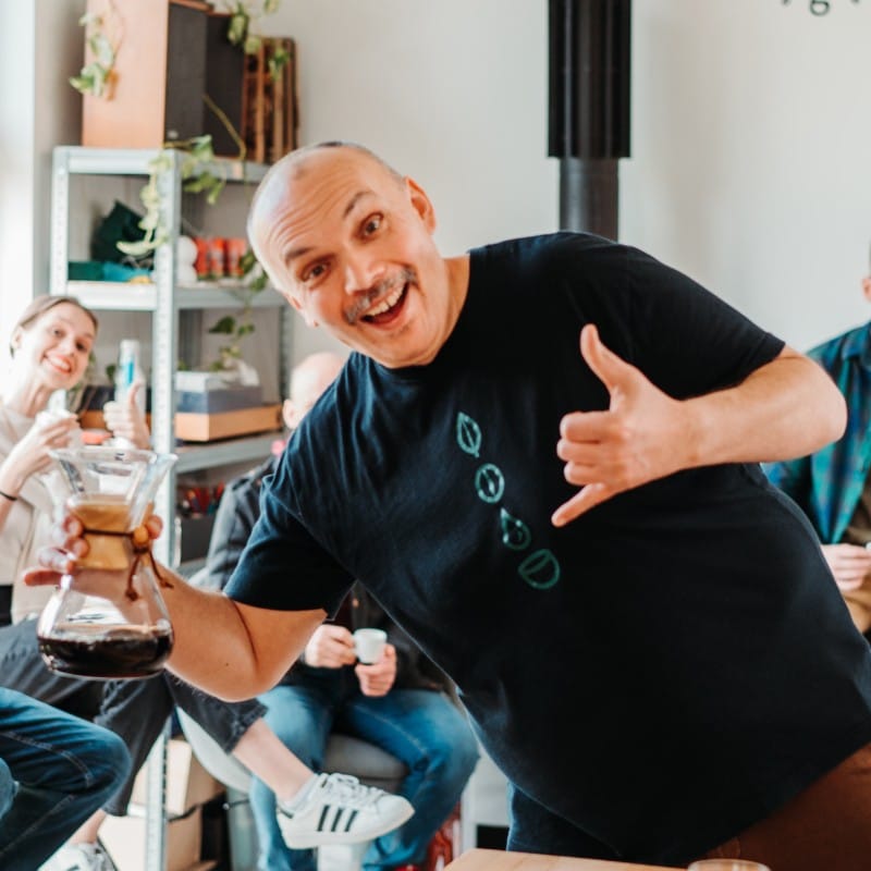 a man holding a glass with a hand and a person holding it